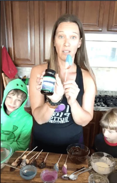 Facebook live screenshot showing Michele Spring holding chocolate covered apples