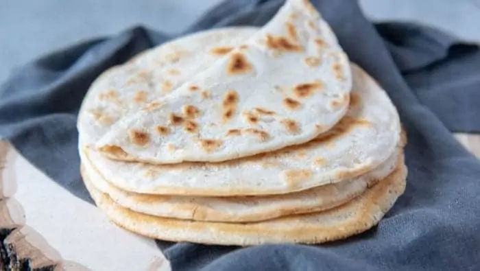AIP Flatbread stacked on a blue napkin with the top one flipped halfway over