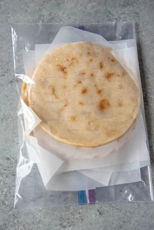 AIP flatbreads laying in a plastic bag, separated by parchment paper