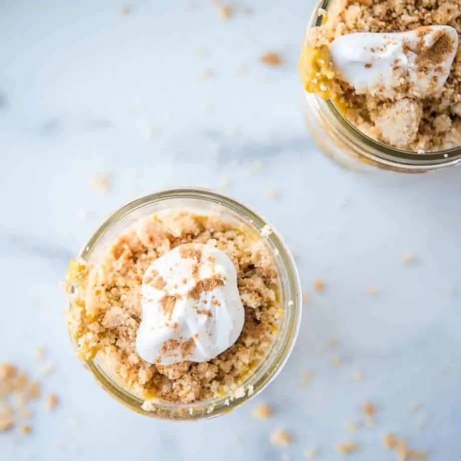 Overhead view of the cookie crumble and coconut whipped cream of this Paleo & AIP pumpkin pudding parfait