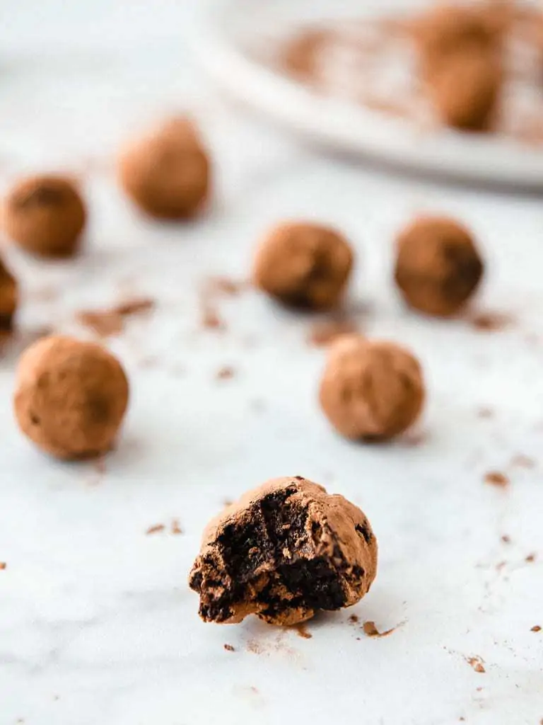 easy AIP dessert truffles with one in the foreground that has a huge bite out of it