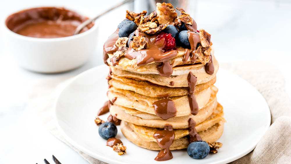 AIP Cassava flour pancakes covered with chocolate sauce and berries