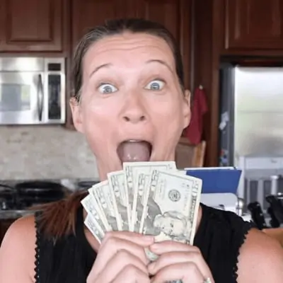 Michele holding a stack of twenty dollar bills