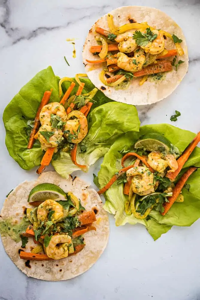 Sheet pan shrimp fajitas on tortillas and lettuce