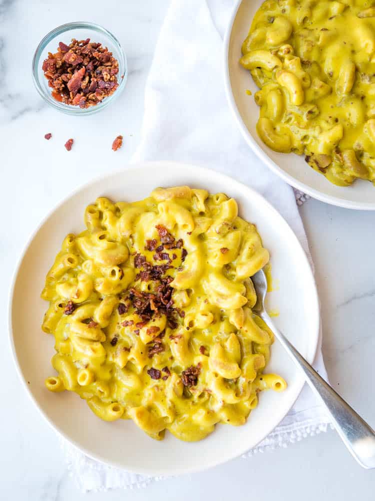 AIP mac and cheese on a plate from above, sprinkled with bacon bits