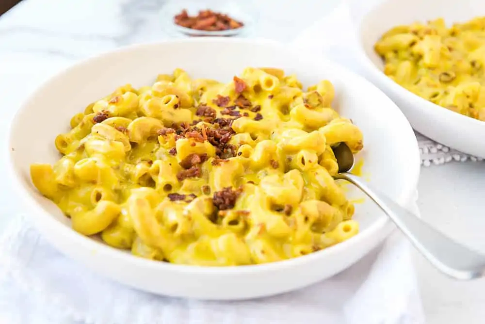 AIP mac and cheese on a plate from the side, sprinkled with bacon bits