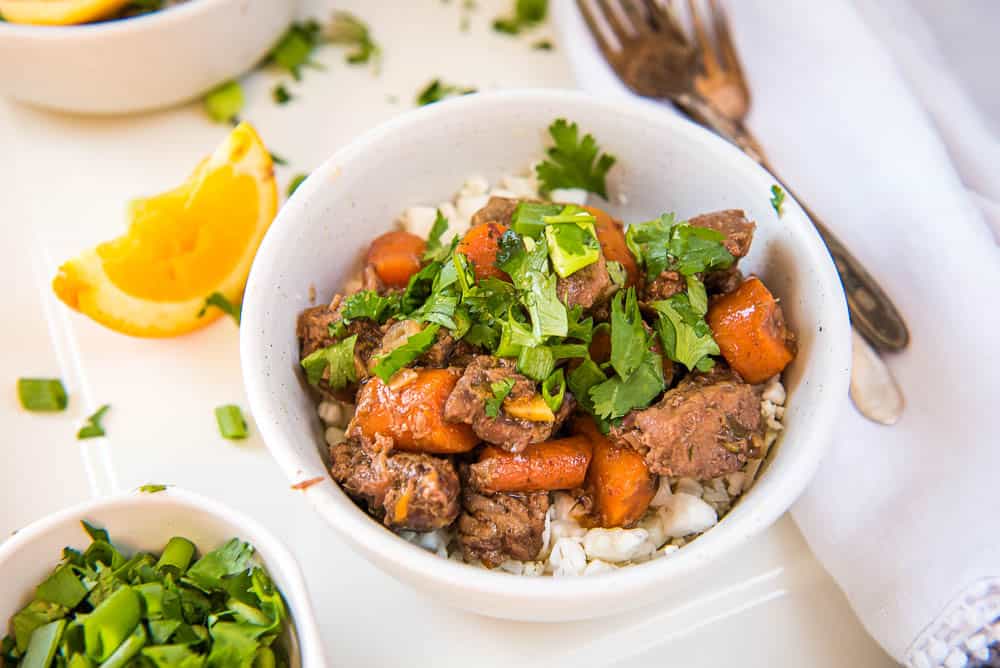 orange ginger beef served over cauliflower rice in a bowl