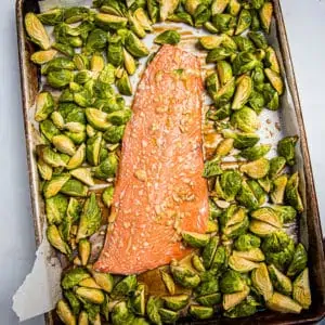 Overhead medium view of salmon and quartered Brussles sprouts on a sheet pan